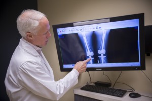 Mills, Mark F., MD looking at an x-ray