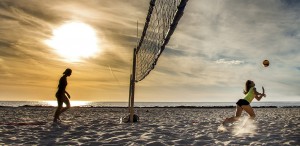 Two people playing volleyball on the beach