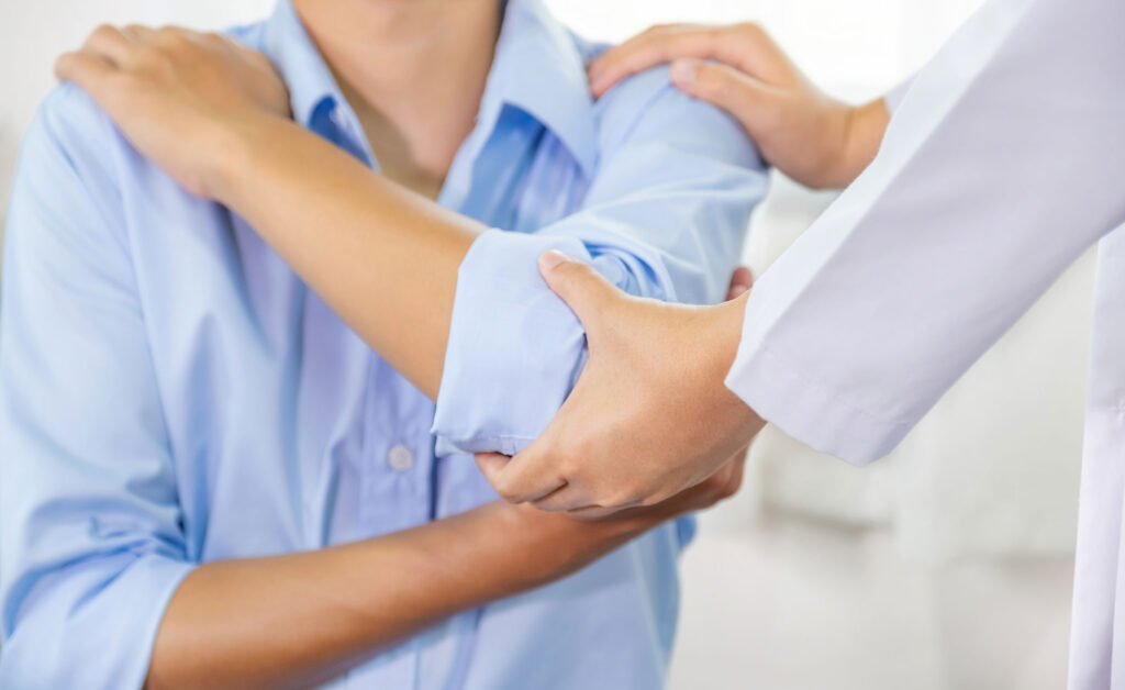 Arm &Amp; Elbow 1 A person holding their elbow in discomfort, representing arm and elbow pain treatment options.
